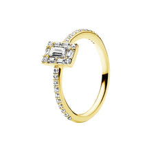 Load image into Gallery viewer, gold ring with emerald-cut diamond and smaller diamonds on a white background stone
